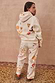 Thumbnail for NFD Cream Sundazed Accessible Hoodie with colourful sun and heart prints, styled with matching joggers.