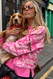 Pink Bandana Copenhagen Jumper with white paisley knit motifs, worn by a model holding a dog for a chic London look.