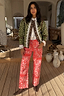 Thumbnail for Red Bandana Jeans in a straight leg fit with a white bandana print, styled with a quilted jacket in an airy room.