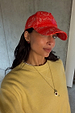 Red Bandana Cap in a cotton paisley print with an embroidered NFD logo, worn by a model in a yellow sweatshirt.
