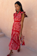 Red Bandana Remi Dress featuring a ruffled neck and leopard print sleeves, styled with a patterned clutch.