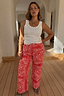 Iconic Red Bandana Jeans in a straight leg fit, styled with a white vest and leopard print heels.