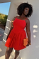Red Broderie Mini Lola Dress in cotton with palm patterns, styled for vacation and inclusive fashion.