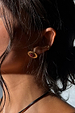 Deloris Red Circle Earrings in textured brushed brass with a red semi-precious stone, shown on a model.