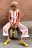 Cream Marina Marra Trousers in a red fish print, paired with a Marina Sol waistcoat and yellow trainers.