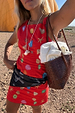 Red Shell Ioana Mini Dress featuring a multicoloured shell print, styled with a woven bag for a vacation look.