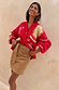 Tan Suede Mini Jaspre wrap skirt on a model styled with a red celestial print cardigan.