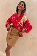 Tan Suede Mini Jaspre wrap skirt on a model styled with a red celestial print cardigan.