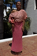 Pink and Red Jacquard Tilly Dress with gold metallic dots and off-the-shoulder neckline in a sunny setting.