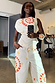 White Snake Asymmetric Top with red snake and star motifs, styled as a co-ord in a mirror selfie.