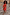 Thumbnail for Tomato Mini Sophie Dress in red with a draped cowl neckline and detachable scarf, styled with a clutch on stone steps.