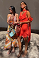 Tomato Mini Sophie Dress in red with a cowl neck and detachable scarf, styled alongside a colourful printed maxi dress.