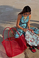 Red Mesh Tote Bag with leather straps and a detachable sun print pouch, styled with a matching jumpsuit.