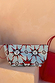 Light blue pouch featuring a sun and swirl print, included with the Red Mesh Tote Bag designed in London.