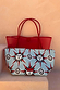 Red Mesh Tote Bag with leather handles and a light blue sun-print pouch on a neutral stone step.