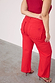Red wide-leg denim jeans featuring scalloped back pockets and an embroidered logo, styled with red heels.
