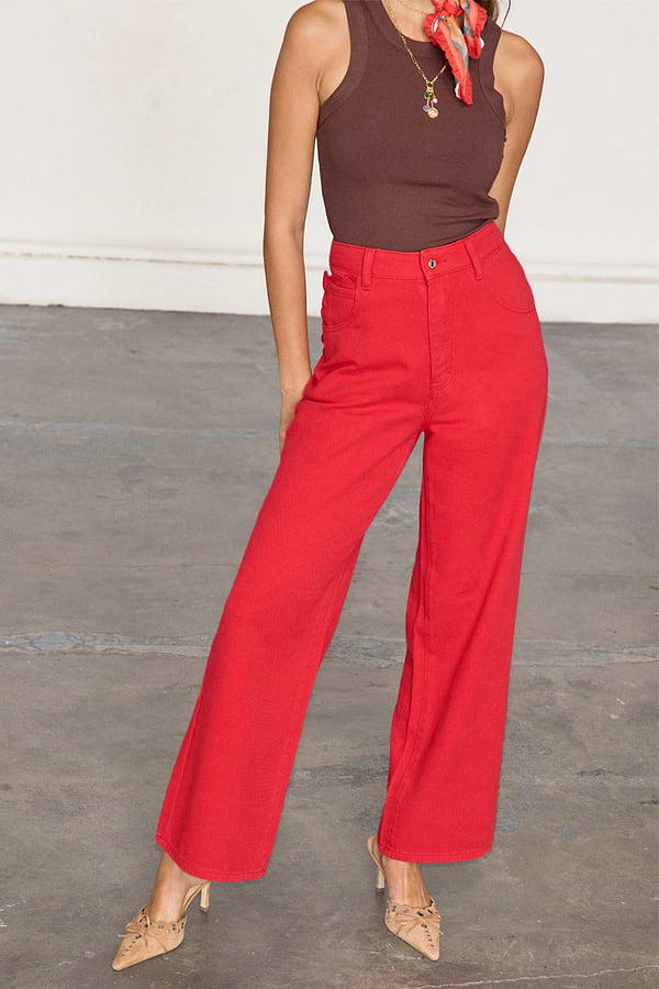 Red Denim Scallop Jeans featuring a wide-leg cut and scalloped pockets, worn with a brown top and heels.