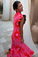 Pink Soleil Remi Dress with red sun motifs and leopard lining on pleated frill sleeves, shown on a smiling woman.