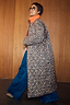 Reversible longline quilted coat in leopard print with an orange collar, styled with blue wide-leg jeans.