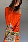 Orange Rio Jem Dress featuring a sun and star print in a relaxed, drop-shoulder silhouette.