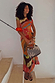 Rio Mesh Dress featuring oversized fruit motifs and warm colour blocks on a stretch mesh base, styled on a model.