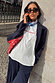 White Rodeo T-Shirt with red text, styled with a pinstripe suit and blue neck scarf for a London look.