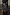 Thumbnail for Black Vegan Leather Ruffle Mini Jaspre Skirt with wrap detailing, styled with black knee-high boots.