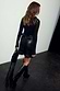 Thumbnail for Black Vegan Leather Ruffle Mini Jaspre Skirt with a wrap tie waist and frilled hem, paired with black boots.