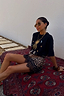 Thumbnail for Iconic black Running Wilder T-shirt in cotton with a sun graphic, styled with a leopard print lace skirt on a red rug.