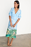 Thumbnail for Blue Scenery May Dress with an Italian Lake Como landscape print, V-neck and puffed sleeves on a model.