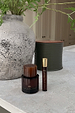 NFD Eau De Parfum 001 in full and travel sizes, designed in London with dark amber glass on a light stone surface.