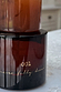 NFD Eau De Parfum 001 in an amber glass bottle featuring gold script lettering on a light stone surface.