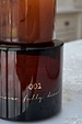 NFD Eau De Parfum 001 in an amber glass bottle featuring gold script lettering on a light stone surface.