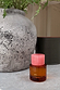 NFD Eau De Parfum 002 in an amber glass bottle with a pink marbled lid, styled beside a rustic grey stone vase.