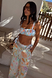 Blue Dreamer Shirred Bandeau Top with sun and palm motifs, styled with matching trousers in a sunny vacation setting.