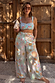 Blue Dreamer Shirred Bandeau Top with a sun and palm print, styled with matching trousers for a vacation look.
