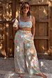 Blue Dreamer Shirred Bandeau Top with a sun and palm print, styled with matching trousers for a vacation look.