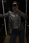 Gunmetal Alexa Sequin Cardigan in a structured silhouette, styled over a grey top and jeans for a party-ready look.