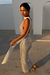 Silver Sequin Maxi Wrap Jaspre Skirt with a waist tie, styled in an outdoor architectural setting.