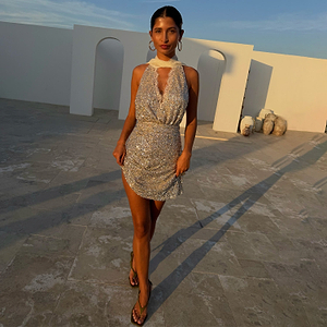 Silver Sequin Mini Jaspre Skirt paired with a matching sequin top on a model against a white arched wall.