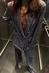 Gunmetal Sequin Freddie Trousers and matching blazer styled as a statement suit inside a lift.