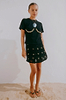 Black Crochet Shell Wrap Skirt with gold shell embellishments, styled with a black shell tee for a vacation look.