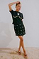 Thumbnail for Black crochet wrap skirt with gold shell embellishments, styled with a shell-detail t-shirt on sand.