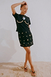 Black crochet wrap skirt with gold shell embellishments, styled with a shell-detail t-shirt on sand.