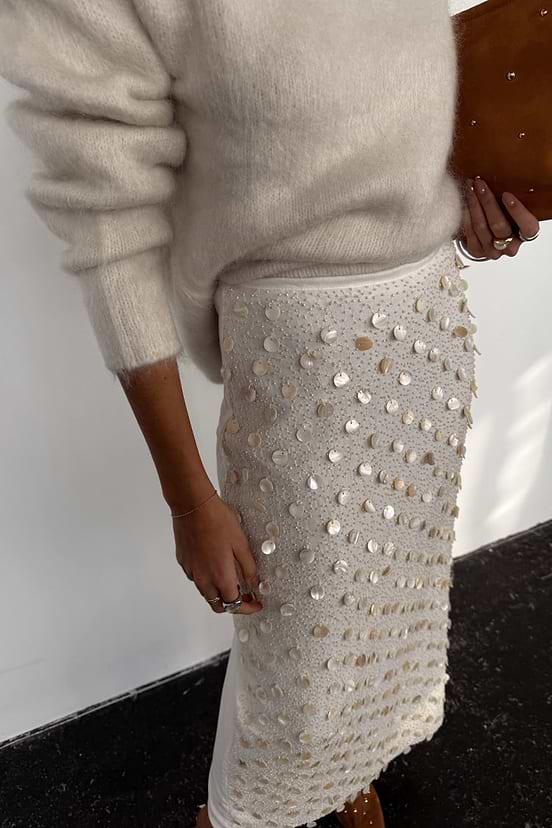 Shells Dorris Skirt in cream featuring pearlescent shell beads and glass details, styled with a fuzzy jumper.