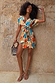 Shell Mini Wrap Dress in an abstract blue and orange print with metallic details and flutter sleeves on a model.