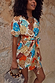 NFD Shell Mini Wrap Dress featuring an abstract shell print with metallic detailing and flutter sleeves.