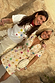 Cream Shell Mini Wrap Dress featuring multicoloured seashell motifs and a wrap tie, worn in a vacation setting.