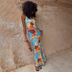 Shell Ribbed Skirt with a blue hand-painted shell print, worn as a maxi co-ord against a stone wall.