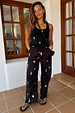 Black Shell Elissa Trousers with a wide-leg fit and metallic gold shell print, styled as a vacation co-ord.